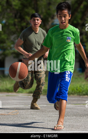 U.S. Marine Corps Lance Cpl. David B. Doran, left, an administrator with the 9th Engineer Support Battalion, plays basketball w Stock Photo