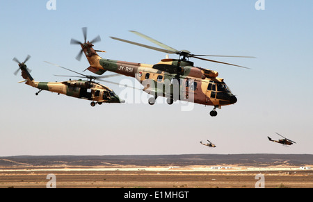 Royal Jordanian Air Force AS332 Super Puma and AH-1 Cobra helicopters fly away after dropping off special operations forces ser Stock Photo