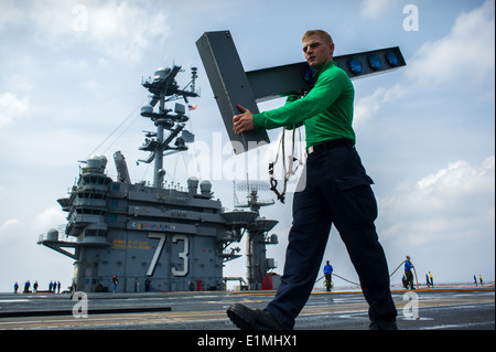 U.S. Navy Interior Communications Electrician Fireman Matthew Pepper, carries a visual landing aid light to prepare for a test Stock Photo