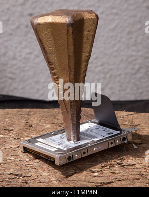 Destroying a computer hard drive by driving a log splitter through it. Stock Photo