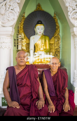 Yangon, Yangon Region, Myanmar. 7th June, 2014. Buddhist monks in front of a statue of the Buddha at Shwedagon Pagoda in Yangon. Shwedagon Pagoda is officially called Shwedagon Zedi Daw and is also known as the Great Dagon Pagoda and the Golden Pagoda. It's a 99 metres (325Â ft) gilded pagoda and stupa located in Yangon. It is the most sacred Buddhist pagoda in Myanmar with relics of the past four Buddhas enshrined within: the staff of Kakusandha, the water filter of Koá¹‡Ägamana, a piece of the robe of Kassapa and eight strands of hair from Gautama, the historical Buddha. (Credit Image: © Stock Photo