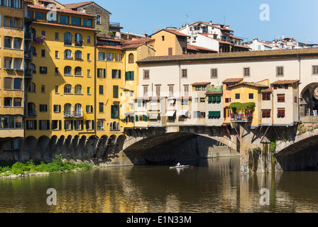 Florence, Florence Province, Tuscany, Italy. Sculler passing under the Ponte Vecchio, or Old Bridge, on the Arno River. Stock Photo