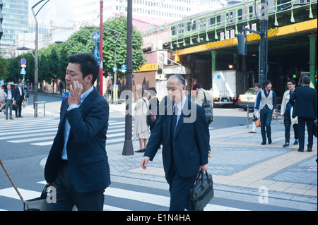 Tokyo Japan 2014 - Men wearing suit crossing stret in Yurachuko Stock Photo