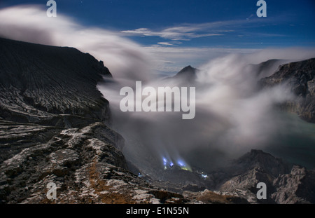 eerie blue light coming from the sulphur mines in the Kawah Ijen volcanic crater, Java, Indonesia Stock Photo