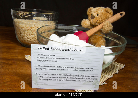 Teddy bear cook making puffed rice cereal cookie treats with recipe on card Stock Photo