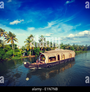 Vintage retro hipster style travel image of Kerala travel tourism background - houseboat on Kerala backwaters. Kerala, India Stock Photo