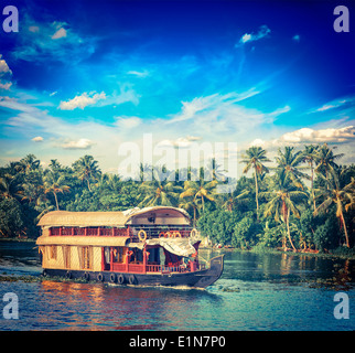 Vintage retro hipster style travel image of Kerala travel tourism background - houseboat on Kerala backwaters. Kerala, India Stock Photo