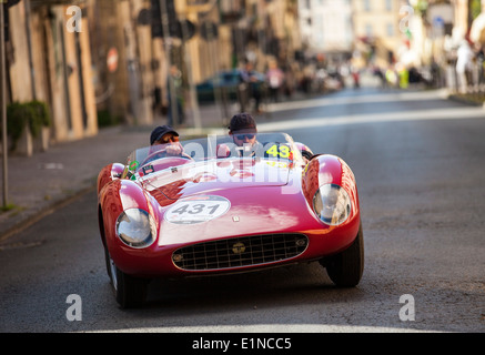 2014 mille miglia classic car rally in Italy. A red 1957 Ferrari 500 TRC Spider is driven up hill in Ronciglione. Stock Photo