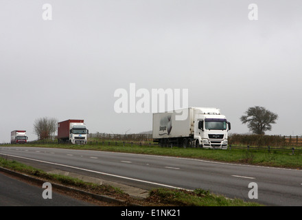 Three trucks traveling along the A417 dual carriageway in The Cotswolds, England Stock Photo