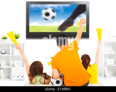 young fans watching soccer game and yell at home Stock Photo