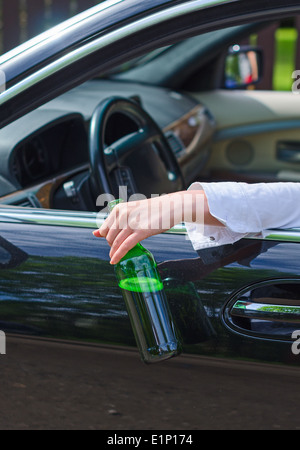 Driving Under the Influence. Female hand with bottle of beer. Stock Photo