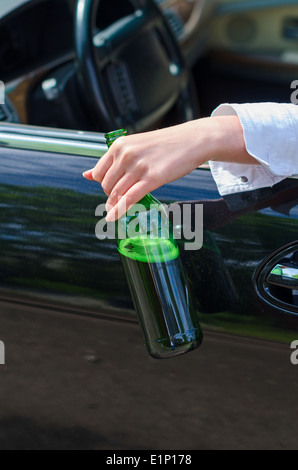 Driving Under the Influence. Female hand with bottle of beer. Stock Photo