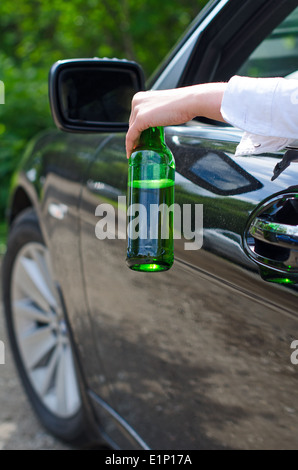 Driving Under the Influence. Female hand with bottle of beer. Stock Photo