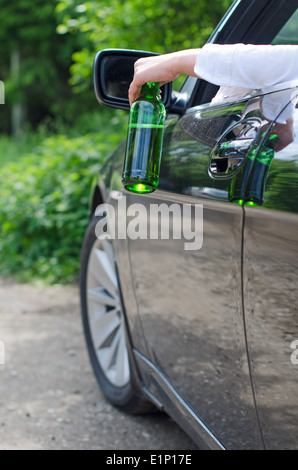 Driving Under the Influence. Female hand with bottle of beer. Stock Photo