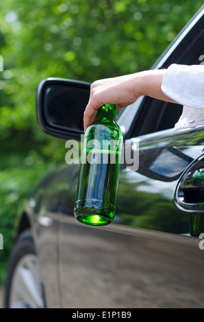 Driving Under the Influence. Female hand with bottle of beer. Stock Photo