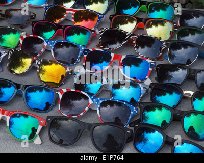 Rows of many colourful sunglasses on sale in street of Taormina Sicily with predominantly blue lens coatings Stock Photo