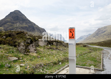 Roadside emergency SOS telephone beside a remote upland country road in mountains. Glen Coe Pass Highland Scotland UK Britain Stock Photo