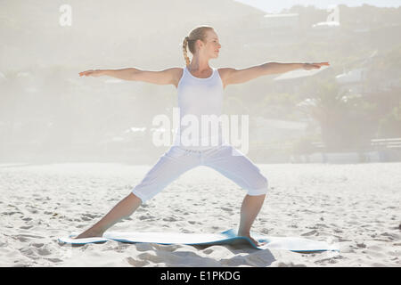 Calm woman standing in warrior pose on beach Stock Photo - Alamy