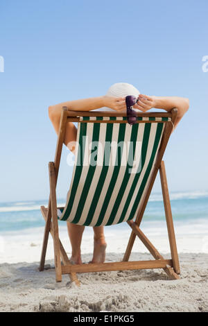 Woman sitting in deck chair at the beach Stock Photo