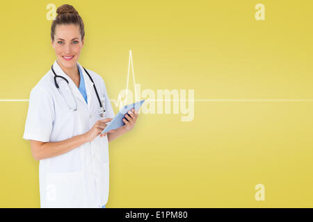 Composite image of pretty nurse using tablet pc Stock Photo