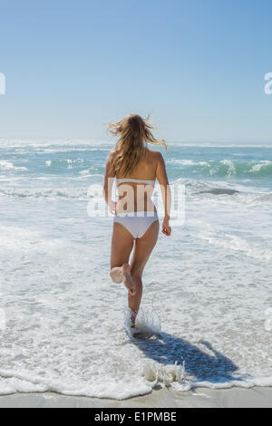 Gorgeous blonde in white bikini running to the sea Stock Photo
