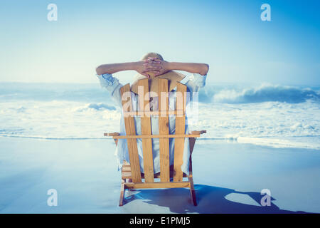 Woman relaxing in deck chair by the sea Stock Photo