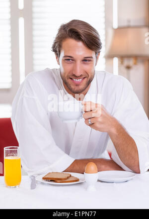 Handsome man having breakfast in his bathrobe Stock Photo