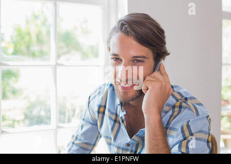 Smiling casual man talking on smartphone Stock Photo