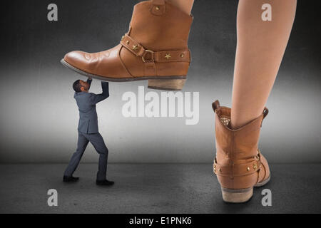 Composite image of cowboy boots stepping on businessman Stock Photo