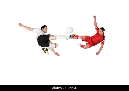 Football players tackling for the ball Stock Photo