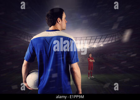 Football players facing off in large stadium Stock Photo