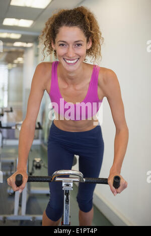 Pretty fit woman on the spin bike smiling at camera Stock Photo