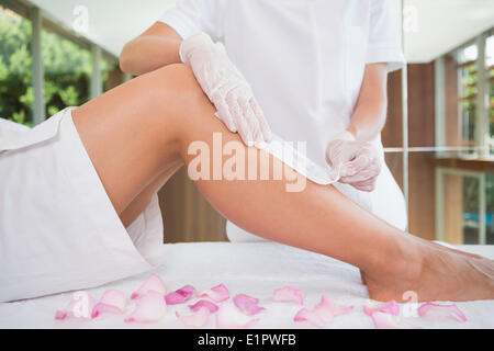 Woman getting her legs waxed by beauty therapist Stock Photo