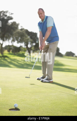 Golfer putting ball on the green Stock Photo