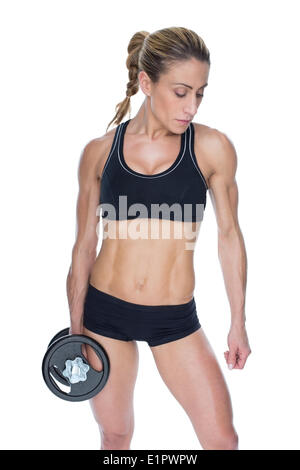 Female bodybuilder holding large black dumbbell with arm down Stock Photo