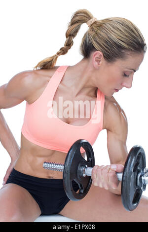 Strong woman doing bicep curl with large dumbbell Stock Photo