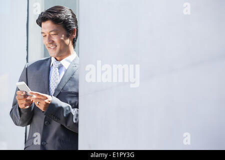 Asian businessman sending text message Stock Photo