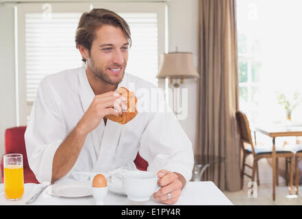 Handsome man having breakfast in his bathrobe Stock Photo