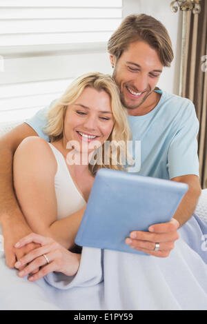 Young couple using tablet pc on the couch Stock Photo