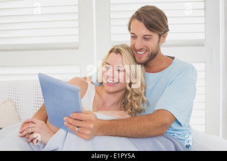 Young couple using tablet pc on the couch Stock Photo
