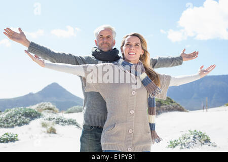 Carefree couple standing on the beach in warm clothing Stock Photo