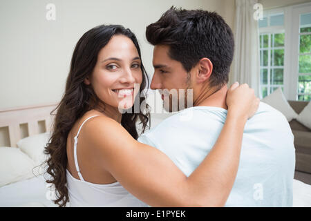 Attractive couple sitting on bed Stock Photo