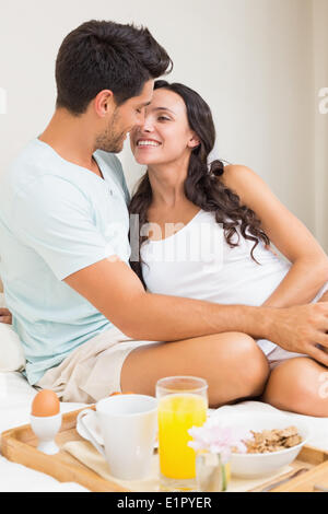 Attractive couple having breakfast in bed Stock Photo