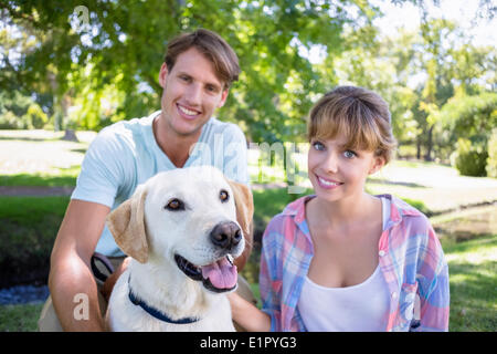 Cute couple with their labrador dog in the park Stock Photo
