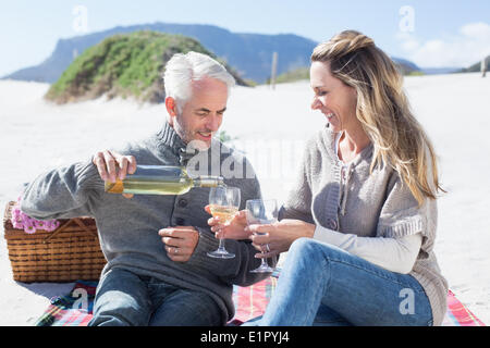 Couple enjoying white wine on picnic at the beach Stock Photo