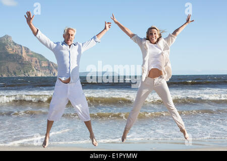 Happy couple jumping on the beach together Stock Photo