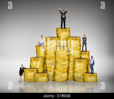 Composite image of business people on pile of coins Stock Photo