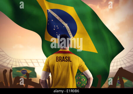 Composite image of brasil football player holding ball Stock Photo