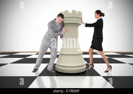 Composite image of business people pushing chess piece Stock Photo