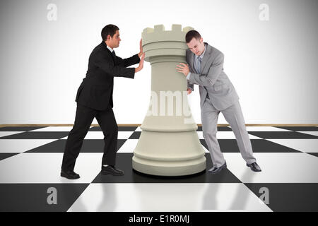 Composite image of business people pushing chess piece Stock Photo